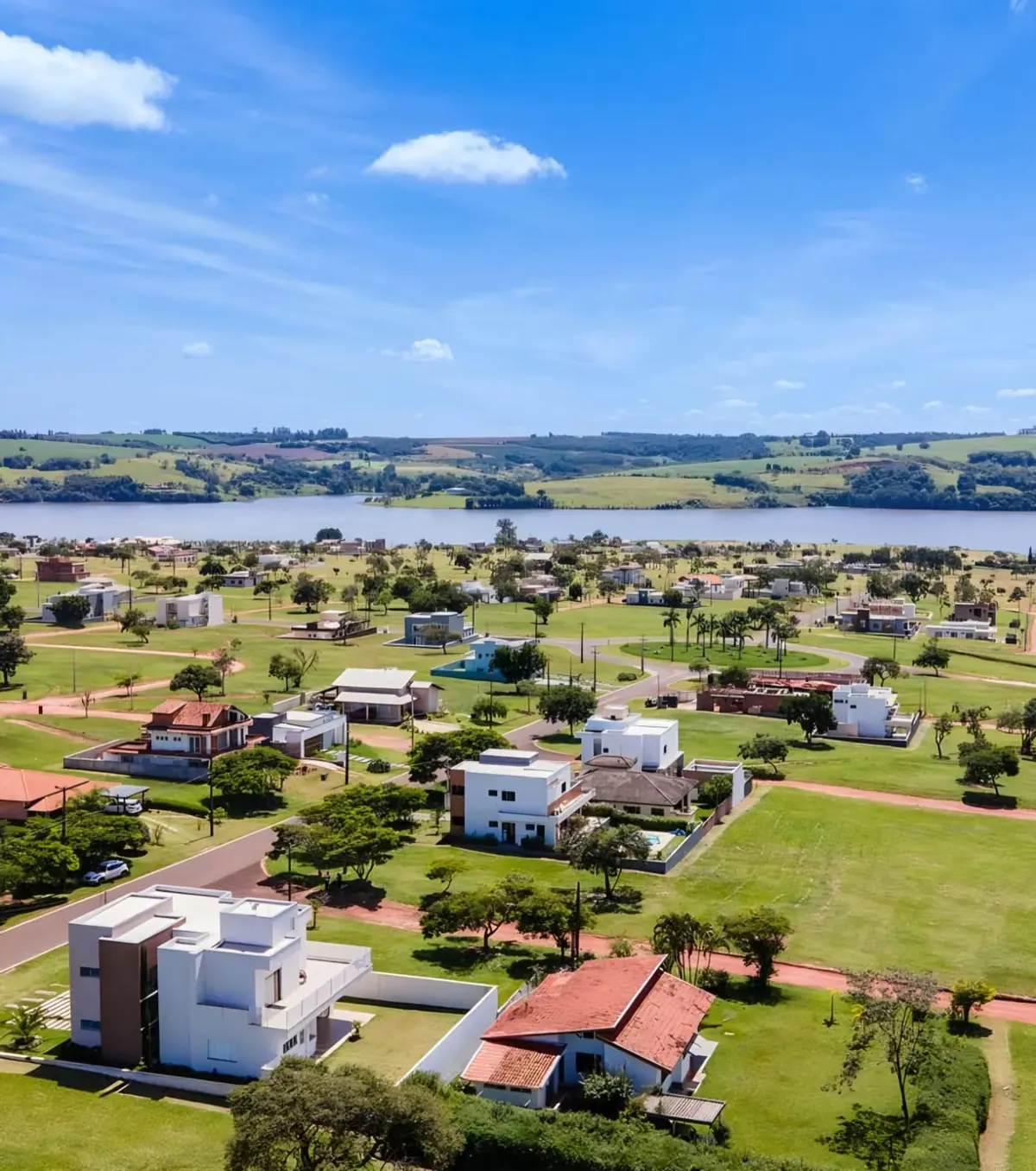 Vista aérea dos lotes e das casas do loteamento, com a represa Jurumirim ao fundo